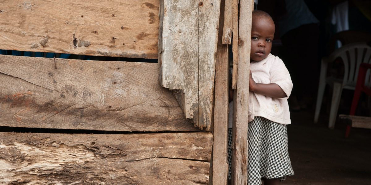 girl standing beside a wooden wall close-up photography