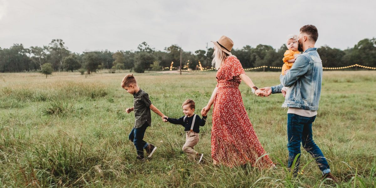 woman holding man and toddler hands during daytime