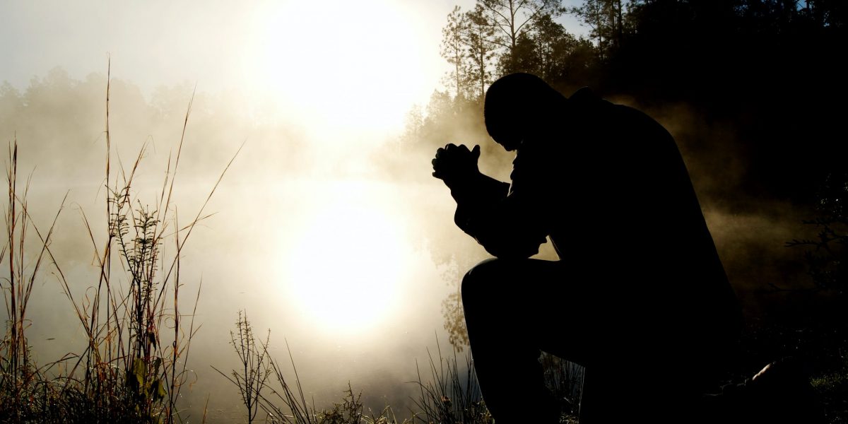 silhouette of kneeling man